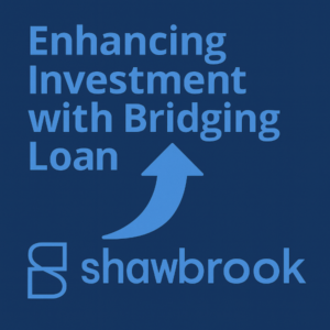 Square graphic on a dark blue background. Large light-blue headline reads “Enhancing Investment with Bridging Loan,” stacked across multiple lines. In the centre is a curved light-blue arrow pointing upward to show enhancement/growth. Along the bottom is the Shawbrook logo, with the stylised “S” mark on the left and the word “shawbrook” to the right.